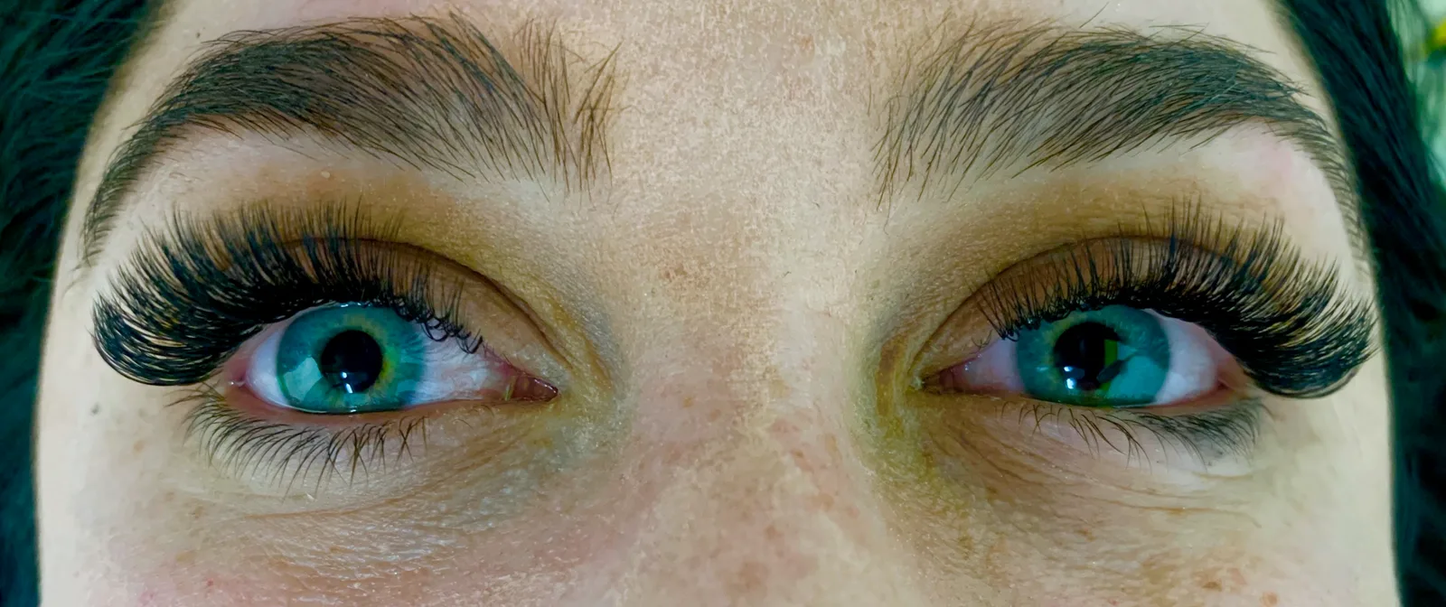 Close-up of both eyes wearing a full set of lash extensions